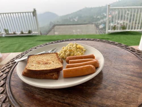 a plate of food with bread and sausage and toast at Villa MYSA in Rāmgarh