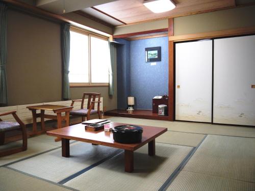 a room with tables and chairs and a large window at KKR Kawayu in Teshikaga