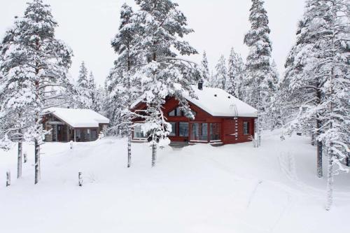 uma cabana numa floresta nevada com árvores cobertas de neve em Villa Kanger em Kuusamo