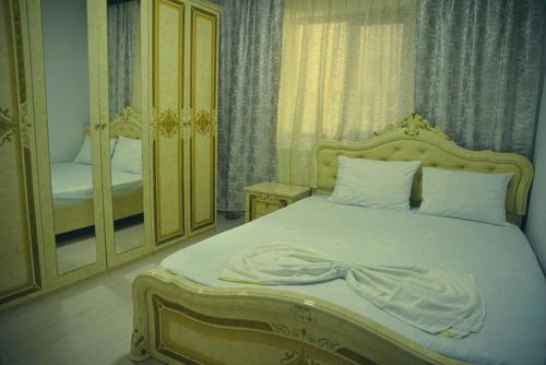 a bedroom with a large bed and a mirror at Casa Rebeka in Năvodari