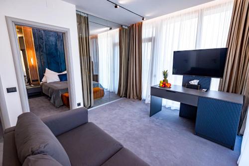 a living room with a couch and a television at Vila Time Olimp in Olimp