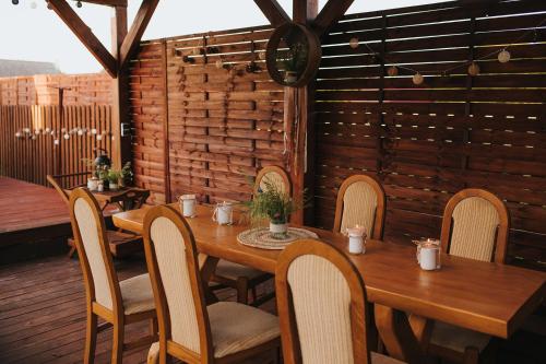 a wooden table and chairs on a patio at PENSJONAT Korycińskie noce i dnie in Korycin