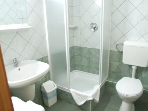 a bathroom with a shower and a toilet and a sink at Lenti Thermal Panzió in Lenti