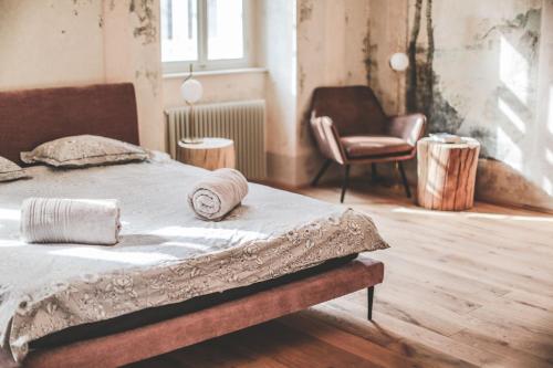 1 dormitorio con 1 cama y 1 silla en Ruttner Suite, en Veszprém