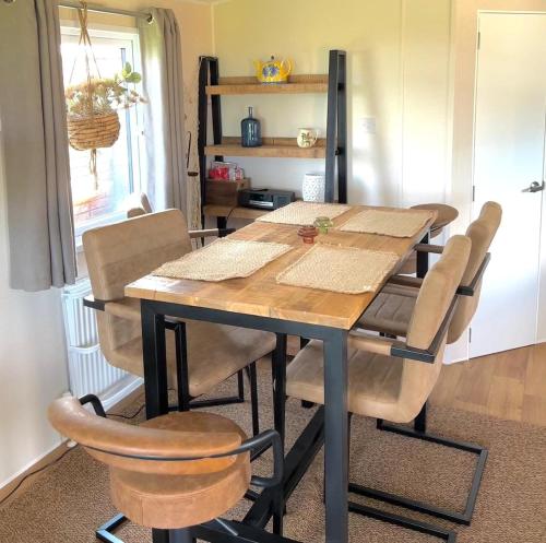 a dining room table and chairs in a room at Traumlage Meerblick Nr 26 Ferienhaus "Schau aufs Meer" erste Reihe unendliche Weite, eingebettet in der Natur in Westerland