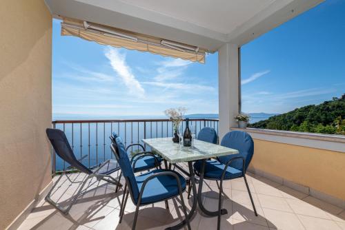 a table and chairs on a balcony with a view of the ocean at Villa Katarina in Mošćenička Draga