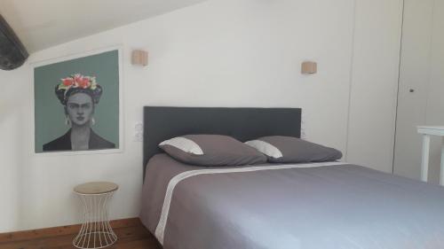 a bedroom with a bed and a portrait of a woman at Appartement centre-ville avec terrasse in Montpellier