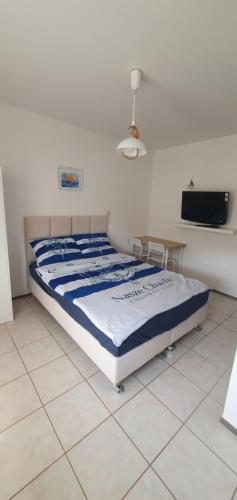 a bedroom with a bed and a flat screen tv at Chabrowa Perła in Jarosławiec
