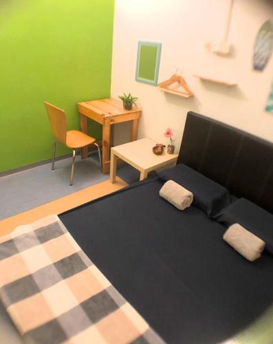 a room with a bed and a table and a desk at Lavender@Guesthouse in Melaka