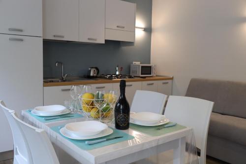 a table with white plates and a bottle of wine at SUNSEA - Enjoy Your Family in Capo Vaticano