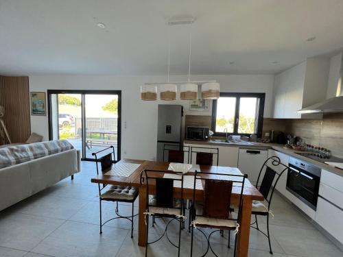 a kitchen and living room with a table and chairs at Casa Lamaghjone - Villa T4 avec piscine chauffée à 3,5km de la mer in Aléria
