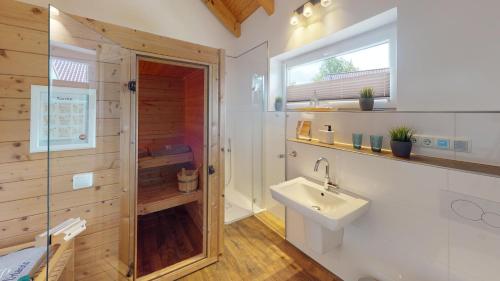 La salle de bains est pourvue de toilettes, d'un lavabo et d'une fenêtre. dans l'établissement Feriendorf Südstrand Haus 36, à Pelzerhaken