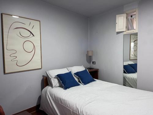 een slaapkamer met een wit bed met blauwe kussens bij Cozy Duplex Príncipe Real in Lissabon
