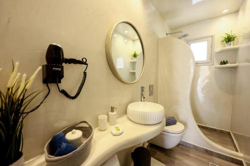 La salle de bains est pourvue d'un lavabo, d'un miroir et de toilettes. dans l'établissement Villa nectar 2 bedrooms 4 pers with Jacuzzi by MPS, à Perivolos