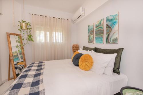 - une chambre avec un grand lit blanc et des oreillers dans l'établissement Inconceptual apartment, à Paradeísion
