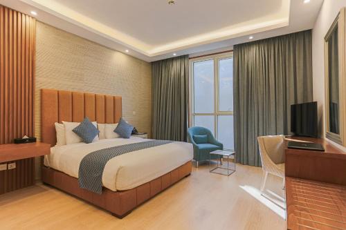 um quarto de hotel com uma cama e uma televisão em Sarwat Park Hotel Riyadh - Diplomatic Quarter em Riyadh