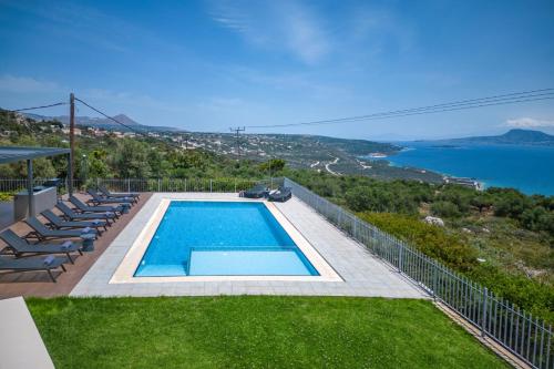 una piscina con sillas y vistas al océano en SeaSilia Luxury Villa en Korakiaí