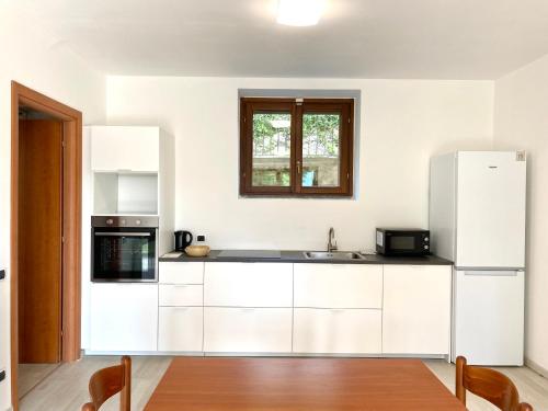 a kitchen with white cabinets and a white refrigerator at A dream on the lake in Ranco