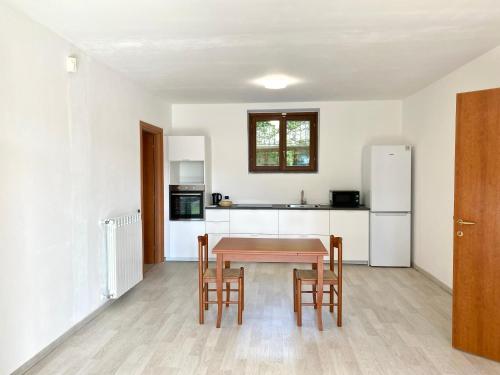 a kitchen with a table and chairs and a refrigerator at A dream on the lake in Ranco
