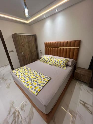 ein Schlafzimmer mit einem Bett mit gelben und blauen Kissen in der Unterkunft appartement de luxe hay almatar 3 in Nador