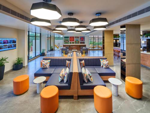 an office with couches and tables and orange chairs at Zone By The Park Gopalpur in Gopālpur