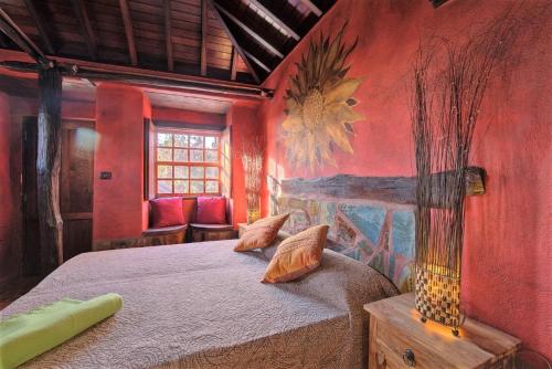 a bedroom with a bed with a painting on the wall at HACIENDA LA CENTENARIA,CASAS RURALES in El Paso