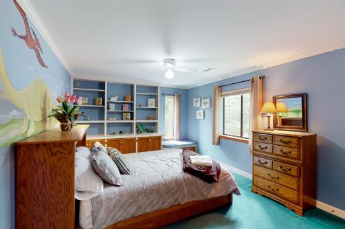 um quarto com paredes azuis, uma cama e uma cómoda em The Cozy House em Trenton