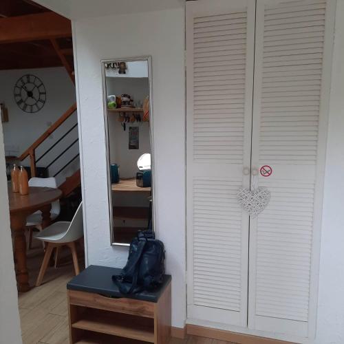 a door in a room with a table and a mirror at Gîte Saint Sauveur in Brévilly