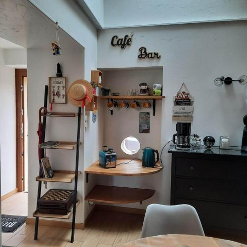 a kitchen with a counter and a shelf with a table at Gîte Saint Sauveur in Brévilly