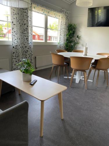ein Esszimmer mit Tischen, Stühlen und Fenstern in der Unterkunft Valla Folkhögskola in Linköping