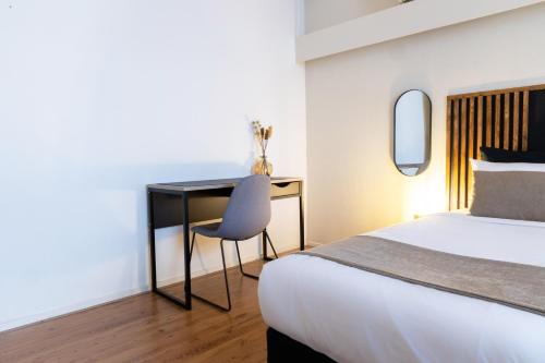 ein Schlafzimmer mit einem Bett und einem Schreibtisch mit einem Stuhl in der Unterkunft Frankendael Apartments in Amsterdam