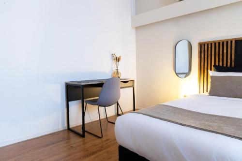 a bedroom with a bed and a desk with a chair at Frankendael Apartments in Amsterdam