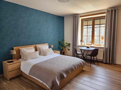 a bedroom with a large bed and a table at Ferme La Joye in Houffalize