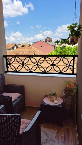 a balcony with two chairs and a table on a balcony at Gold lux in Čačak