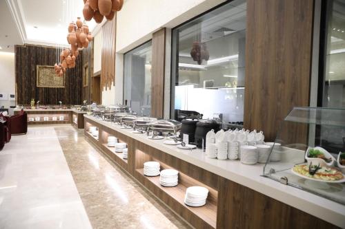 a buffet line in a restaurant with white plates at Dorat Najd Resort in Riyadh