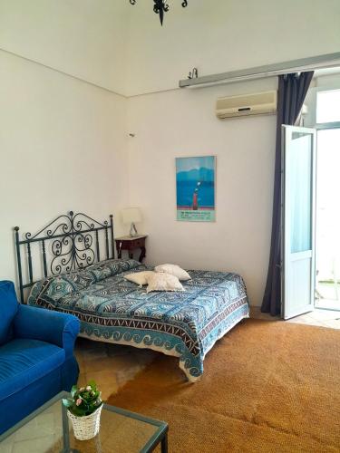 a bedroom with a bed and a blue couch at Casa Marina in Forio d'Ischia