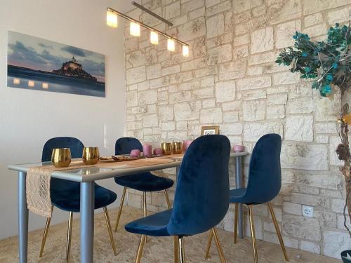 a dining room with a table and blue chairs at Unique Munich Apartment in Unterhaching