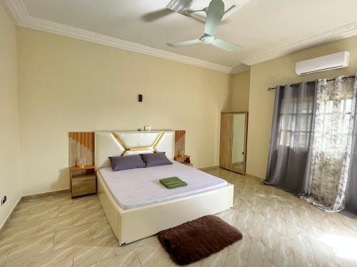 1 dormitorio con 1 cama y ventilador de techo en Appartement moderne 2chambres, en Cotonou