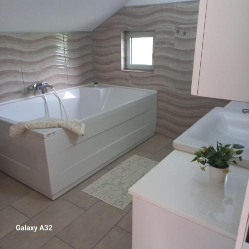 a bathroom with a white tub and a sink at Kuća za odmor Lohovo in Bihać