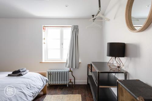 a bedroom with a bed and a desk and a window at Riders Lodge - STAY LAGOM in Ballycastle