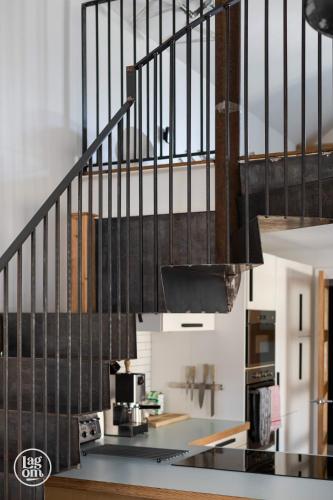a kitchen with a staircase with a coffee maker under a stair case at Riders Lodge - STAY LAGOM in Ballycastle