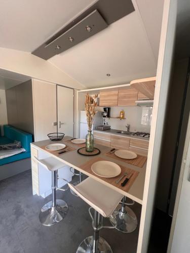 une cuisine avec une table et des chaises dans une pièce dans l'établissement Mobil Home du Lac - Camping 4 Étoiles, à Aureilhan