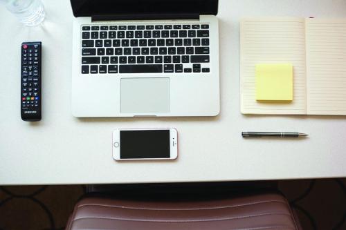 a desk with a laptop and a pen and a book at Delta Hotels by Marriott Dubai Investment Park in Dubai