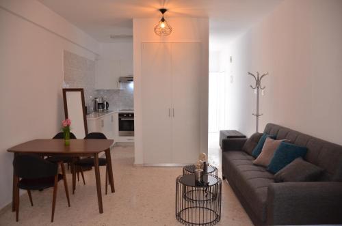 una sala de estar con un sofá y una mesa en Almyria Apartments - By IMH Travel & Tours, en Pafos