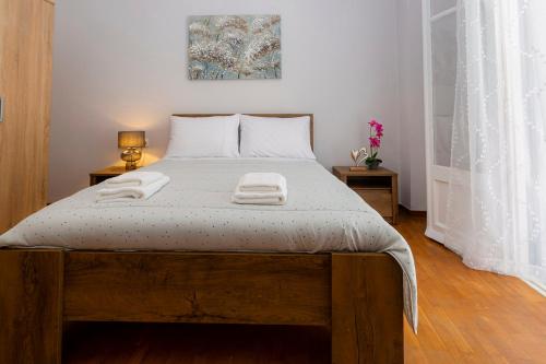 a bedroom with a bed with two towels on it at H&G Old Town Apartment in Corfu