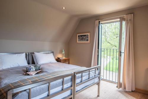 a bedroom with a bed and a sliding glass door at Gardiners Cottage Barn in Eye