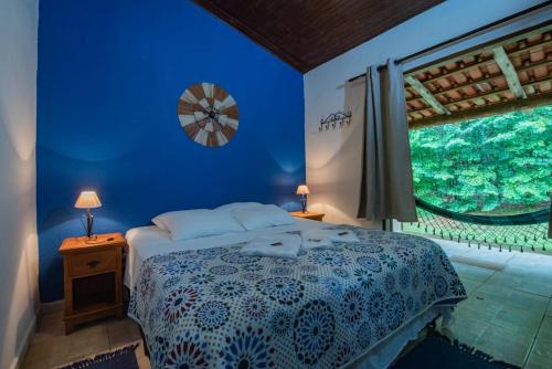 a blue bedroom with a bed and a window at Praia da Crioula in Vargem Bonita