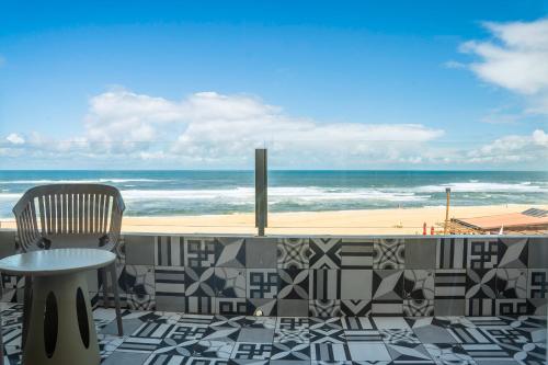 un patio con tavolo, sedia e spiaggia di Hotel Cristal Vieira Praia & SPA a Praia da Vieira