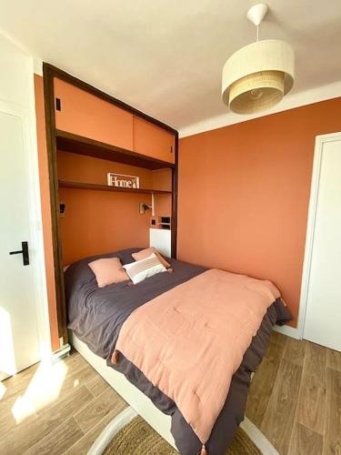 une chambre avec un lit avec un mur orange dans l'établissement Joli T2 en centre-ville Lorient avec balcon cosy, à Lorient