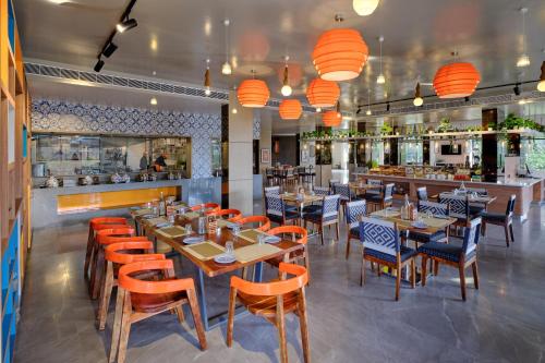 a restaurant with tables and chairs and a bar at Zone By The Park Gopalpur in Gopālpur